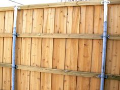 a wooden fence with metal pipes attached to it