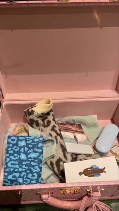 an open pink suitcase filled with clothing and accessories