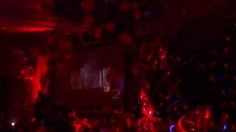 a blurry photo of people dancing in a dark room with red and blue lights