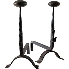 two black iron candlesticks with one candle holder and the other is turned upside down