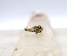 This lover's knot ring represents two people joining as one. These are two individual rings that are intertwined forming the knot.  Hallmarked 1977, this ring is in wonderful condition.   Measurements: 8 - 2.6 mm wide / 2.7 mm high off finger Metal: 9k yellow gold  Size: 6 Markings: hallmarked dated 1977 London with Makers Mark Circa: 1977 Weight: 2.4 grams Condition Rating: 8 (some oxidation with minor wear) Lovers Knot, Knot Ring, Christmas Deals, Love Knot, Note 8, Two People, Makers Mark, Rings Statement, Hallmark