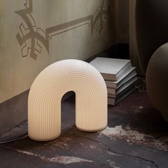 a white object sitting on top of a floor next to a pile of books