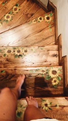 a person is standing on the stairs with sunflowers painted on them and their feet are up