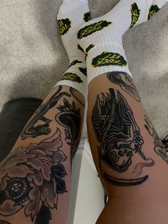 the legs and ankles of a woman with tattoos on her body, both wearing socks