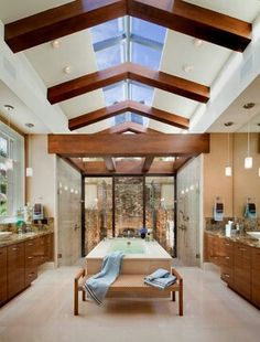 a large bathroom with a skylight above the bathtub