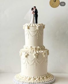 a wedding cake with a bride and groom on top