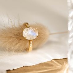 The Moonstone Ring (Serena) features an oval rainbow moonstone set on a gold tapered band. This elegant statement ring is flanked by cubic zirconia stones that shine brilliantly like diamonds. We love this ring because of its intriguing blue and white tones!


The rainbow moonstone measures 10mm x 8mm.
 Size: 4, 5, 6, 7, 8, 9, 10 Trendy Ring, Big Rings, Detailed Ring, Moonstone Jewelry, Cheap Jewelry, Sustainable Jewelry, Traditional Jewelry, Moonstone Ring, Rainbow Moonstone