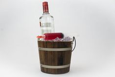 an empty bottle sitting on top of a wooden barrel