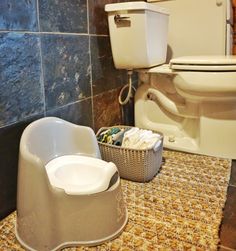 a white toilet sitting next to a bath tub in a bathroom on top of a tiled floor