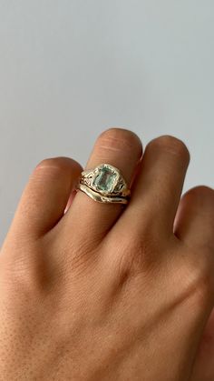 a woman's hand with a gold ring and an aquamarine blue topaz