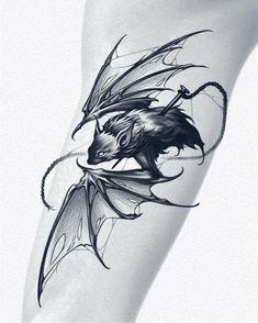 a black and white photo of a dragon tattoo on the leg, with its wings spread out