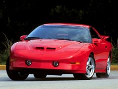 a red sports car driving down the road