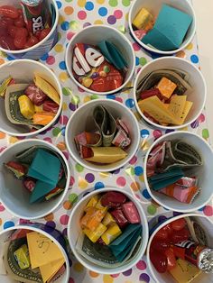 several bowls filled with different types of candy and confection on a polka dot table cloth