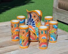 a group of vases sitting on top of a wooden table