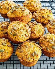 several muffins on a cooling rack with pumpkin seeds