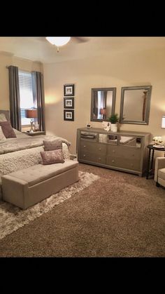 a bedroom with a bed, dresser and mirror in the corner next to a couch