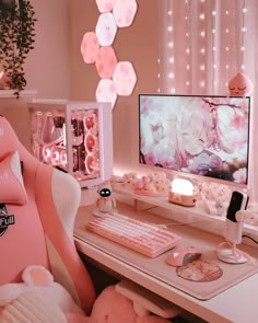 a desk with a computer, keyboard and mouse in front of a pink flowered wall