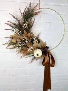 a wreath hanging on the side of a brick wall with flowers and leaves in it