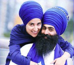 two men in blue turbans hugging each other