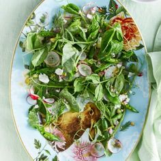 a blue plate topped with greens and radishes