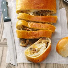 sliced bread with meat and cheese on it next to a knife, fork and bowl