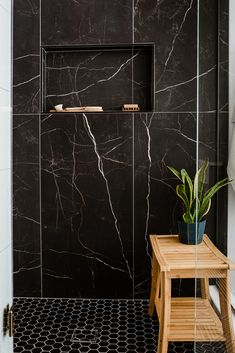 a bathroom with black marble walls and floor