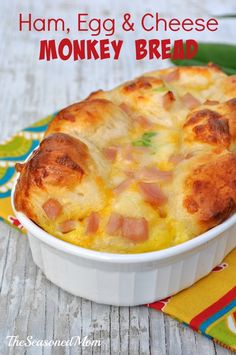 ham, egg and cheese monkey bread in a white casserole dish on a colorful napkin