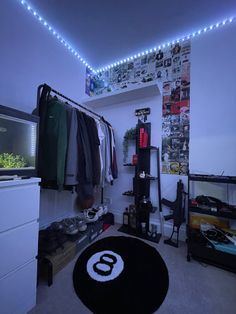 a bedroom with clothes hanging on the wall and a black rug in front of it