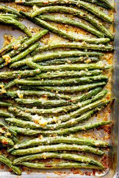 cooked asparagus in a baking dish with parmesan cheese and seasoning