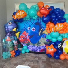 an assortment of balloons in the shape of fish and sea animals on display at a birthday party