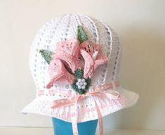 a crocheted hat with pink flowers on it