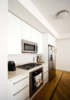 a kitchen with white cabinets and stainless steel appliances