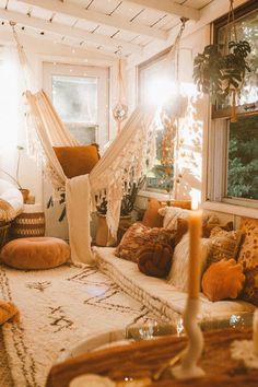 a living room filled with lots of furniture and pillows on top of a white rug