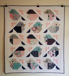 a quilted wall hanging with birds on it