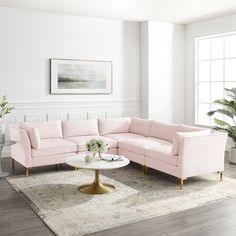 a living room with pink couches and white rugs on top of a wooden floor