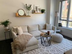 a living room filled with furniture and a large white rug on top of a hard wood floor