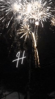 fireworks are lit up in the night sky with numbers written on them and snow covered ground