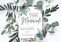 the wedding card is surrounded by greenery