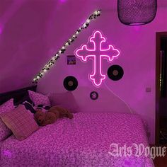 a bed room with a neatly made bed and a cross on the wall above it