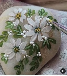 a rock with flowers painted on it