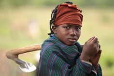 a woman with an orange turban holding a wooden stick