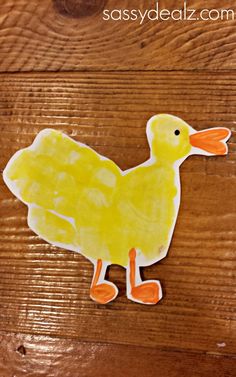 a duck made out of paper sitting on top of a wooden table