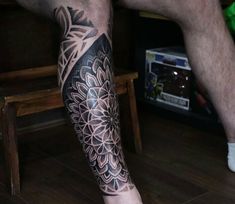 a man's leg with a flower tattoo on it