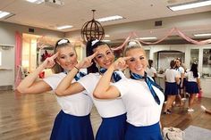 two girls in blue skirts are posing for the camera