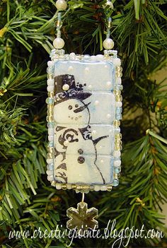 a snowman ornament hanging from a christmas tree