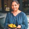 a woman holding a bowl full of food