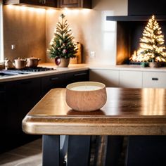 a wooden table with a bowl on it in front of a stove and christmas trees