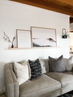 a living room filled with furniture and pictures on the wall above it's couch