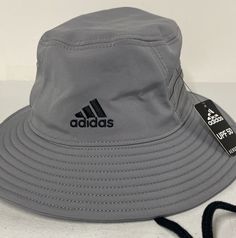 a grey adidas hat with a black logo on the side and a white tag attached to it