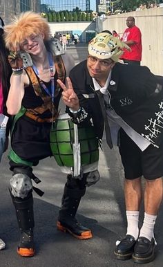 three people in costumes posing for the camera with one person holding up his peace sign